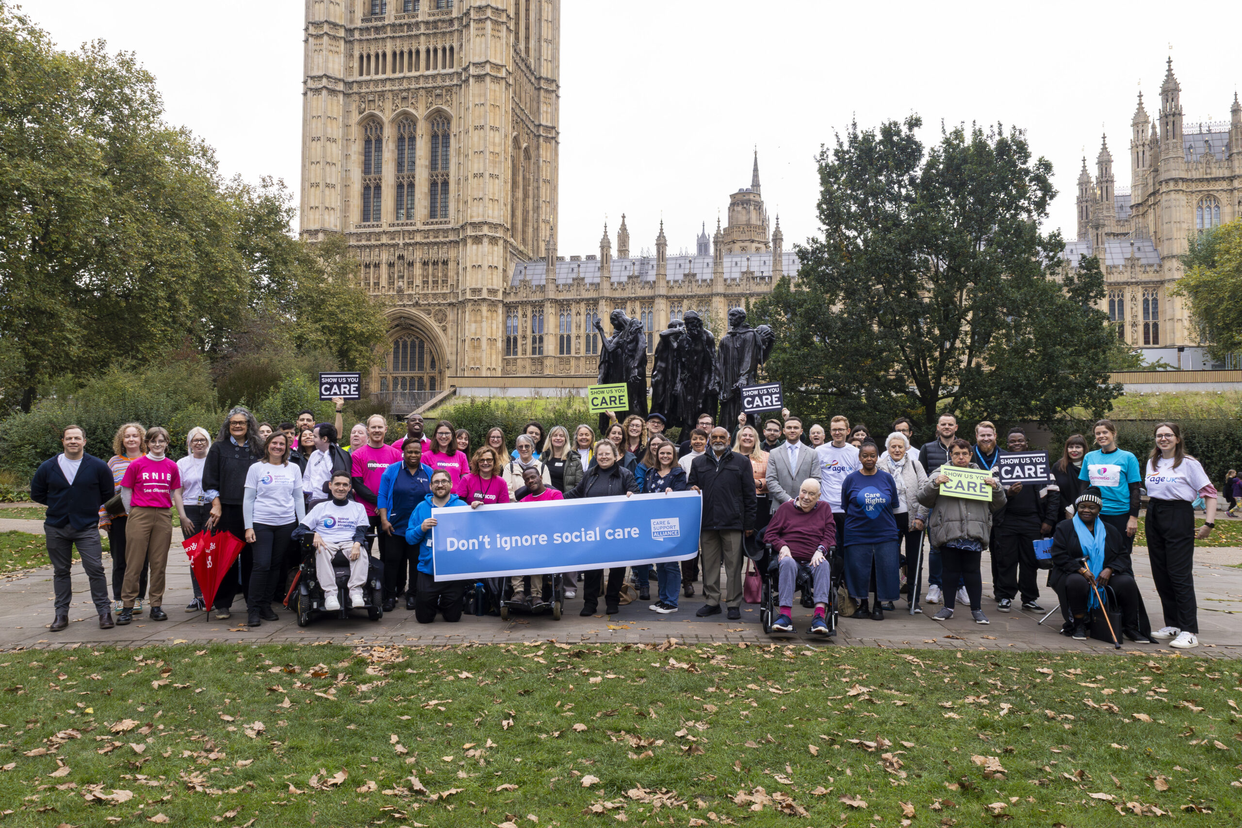 A group of over 60 campaigners gather outside parliament with messages calling on the government not to forget social care.at the upcoming Budget.